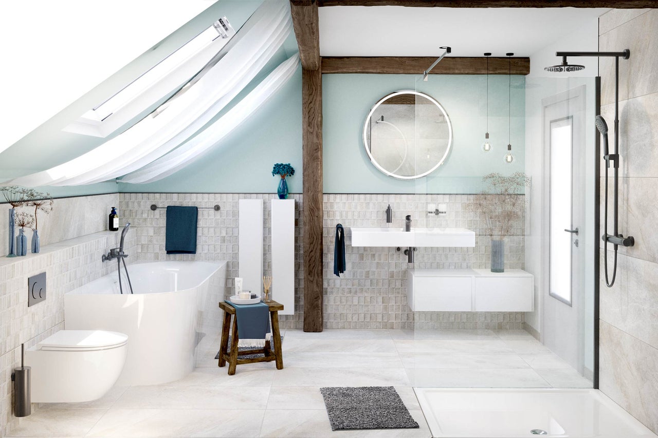 Lichte badkamer met bad, douche, wastafel en toilet onder een dakraam