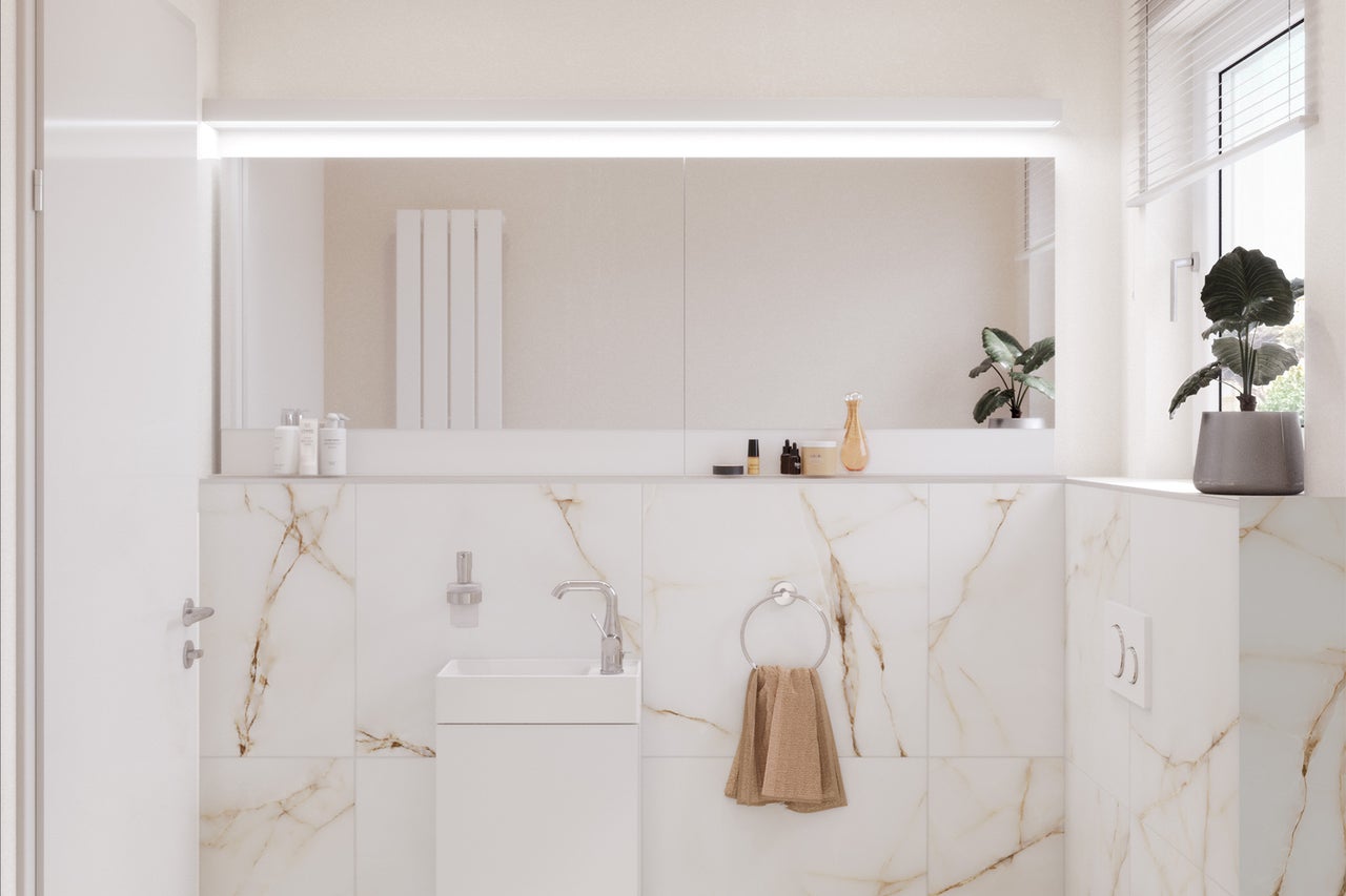 Lichte badkamer met wastafel, spiegel en marmeren tegels