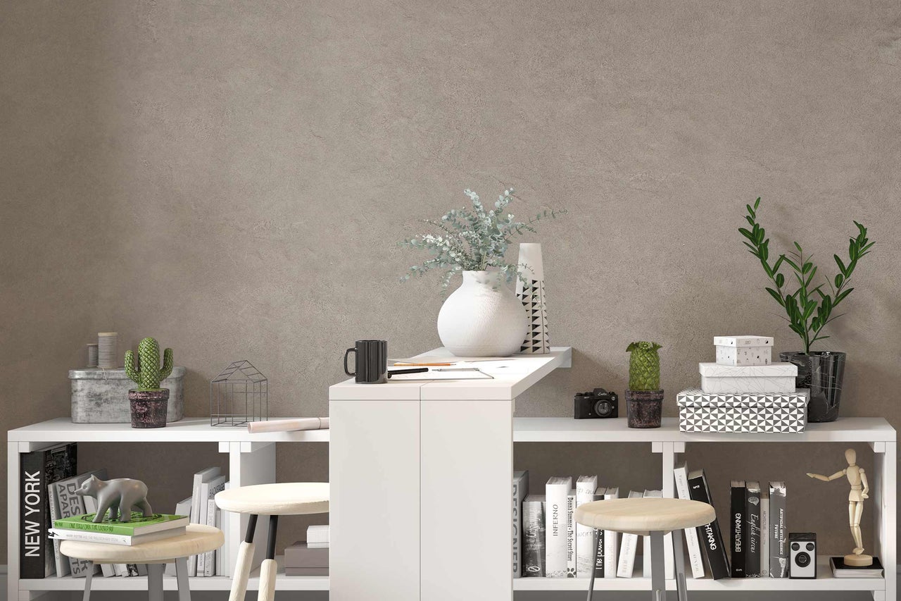 Kamer met witte rekken, krukken, kamerplanten en decoratieartikelen voor een muur