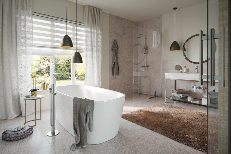 Badkamer met ligbad, douche, wastafel en accessoires voor een ontspannen sfeer