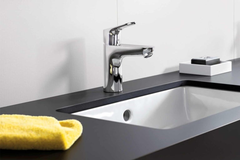 Wastafel met kraan en plank in de badkamer