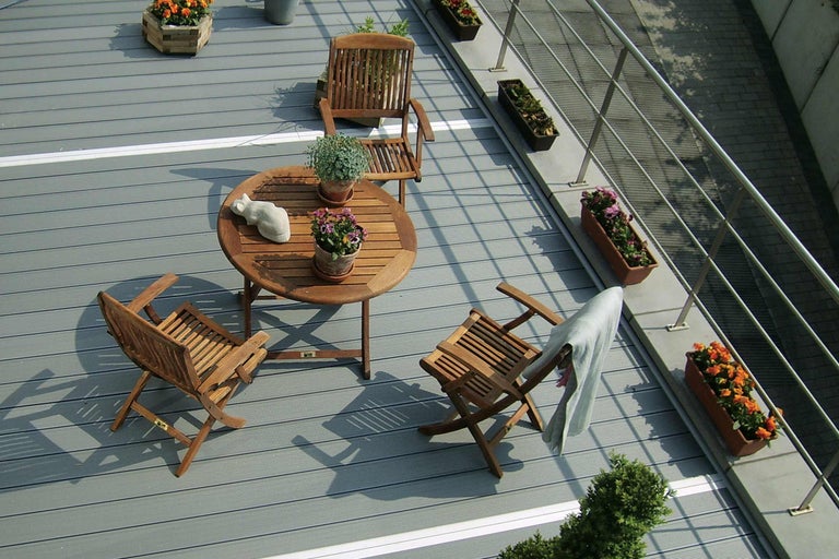 Terras met houten vloer, houten tafel en houten stoelen
