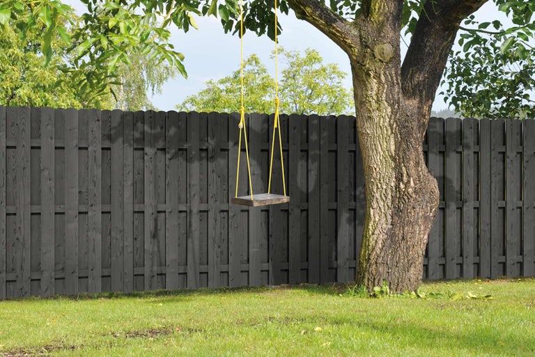 Scene met een houten schutting en een schommel aan een boom