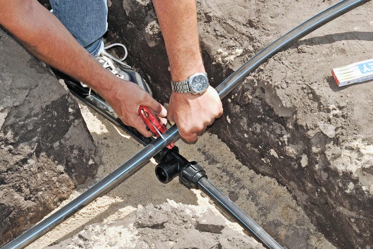 Installatie van een irrigatieleiding met een T-stuk en pijpsnijder