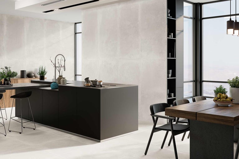 Lichte, moderne keuken met kookeiland, eettafel en stoelen.