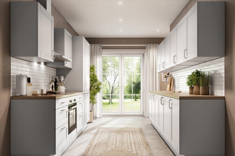 Moderne parallelkeuken met witte kaderfronten, houten werkbladen en witte tegels. Lichte ruimte met uitzicht op de tuin.
