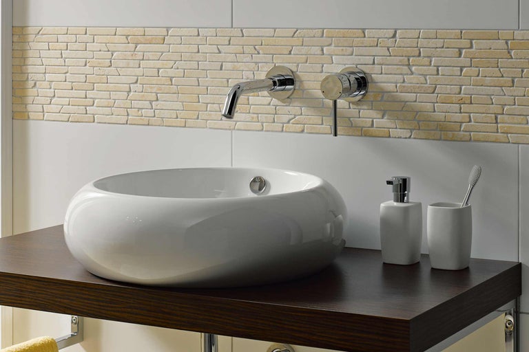 Moderne badkamer met waskom, kraan en wandtegels in steenlook