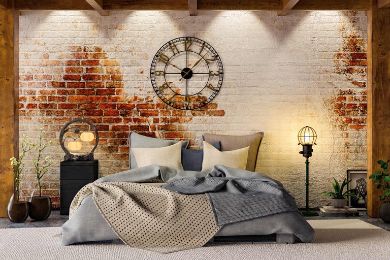 Slaapkamer met bed, nachtkastje, wandklok en decoratieve verlichting voor een bakstenen muur