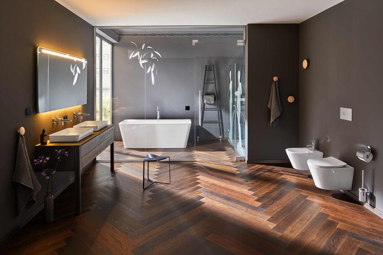 Badkamer met bad, douche, wastafel, toilet en bidet in donkere kleuren