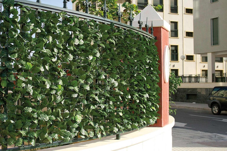 Schutting met kunstmatige klimopbladeren als privacyscherm