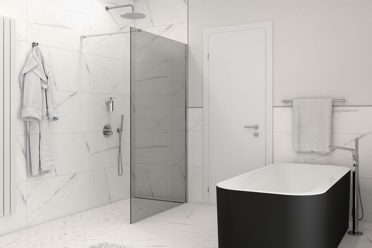 Badkamer met bad, douche, handdoeken en radiator