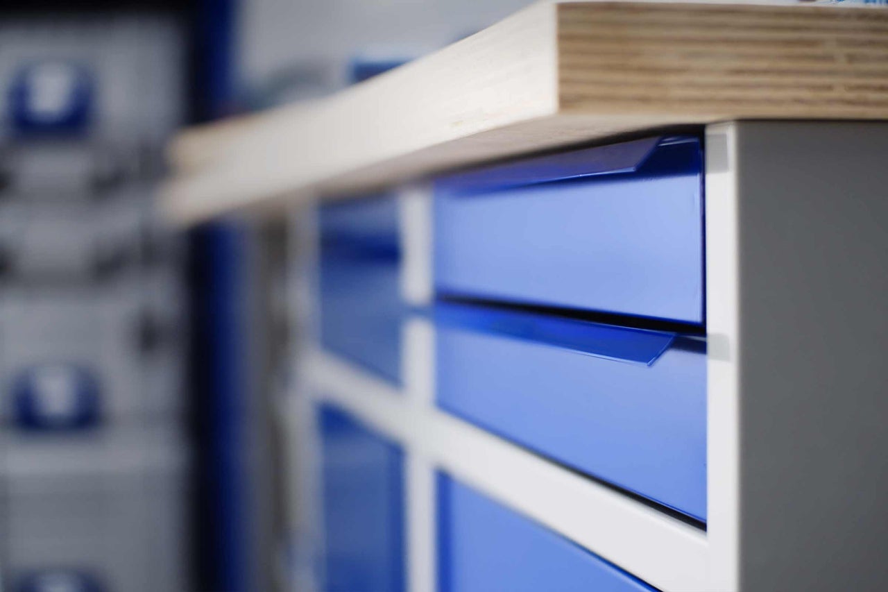 Werkbank met blauwe laden en houten blad