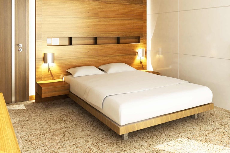 Slaapkamer met tweepersoonsbed, nachtkastjes en houten wand