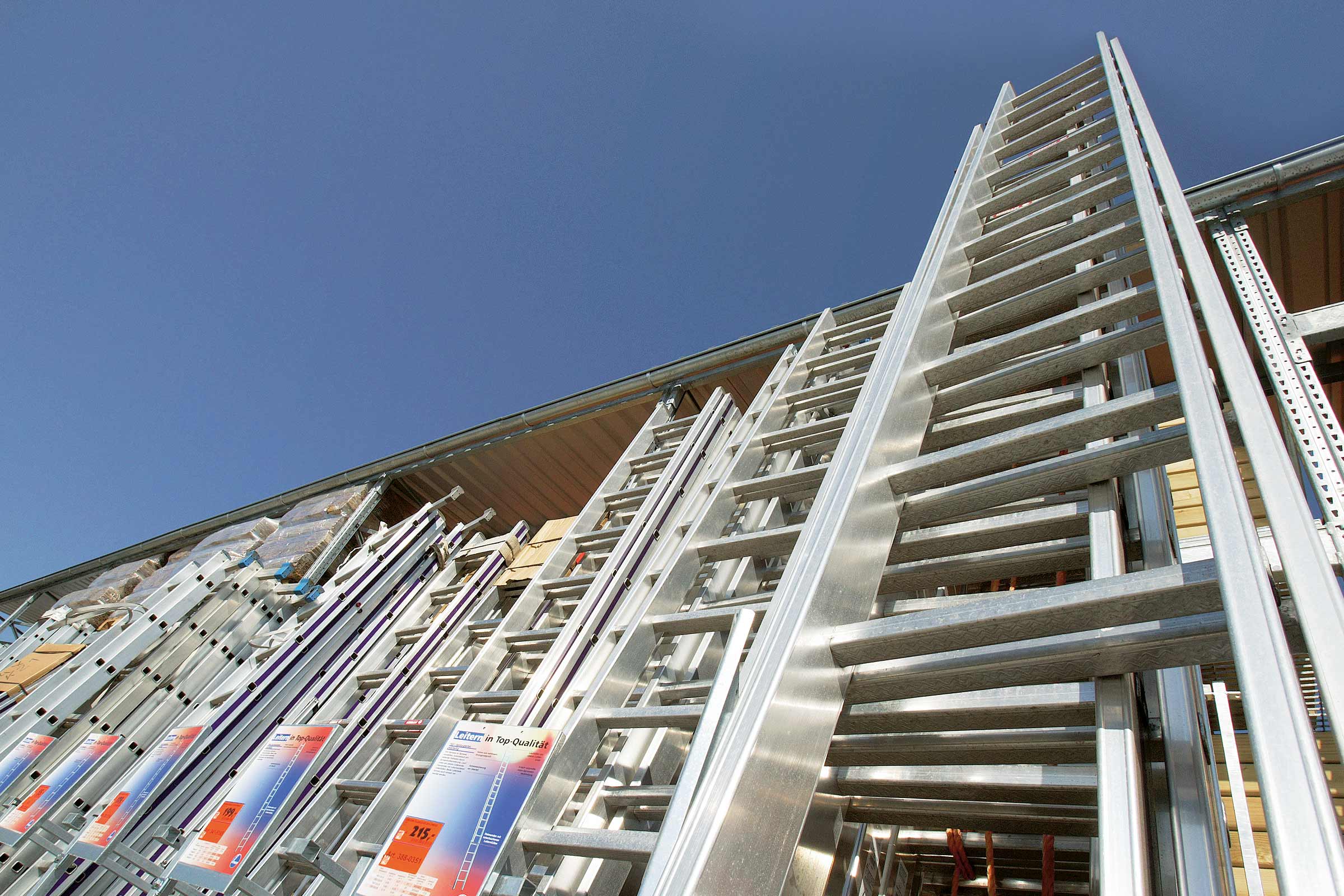 Diverse aluminium ladders van verschillende afmetingen onder een blauwe hemel
