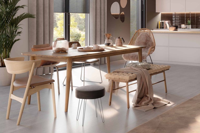 Eetkamerset met houten tafel, stoelen, bank en kruk in een lichte en uitnodigende eetkamer.