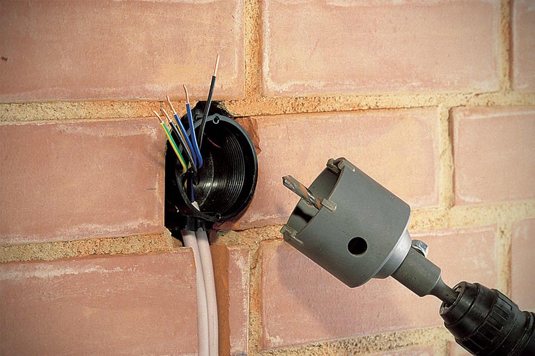Elektrische installatie in een bakstenen muur met gatenzaaggereedschap