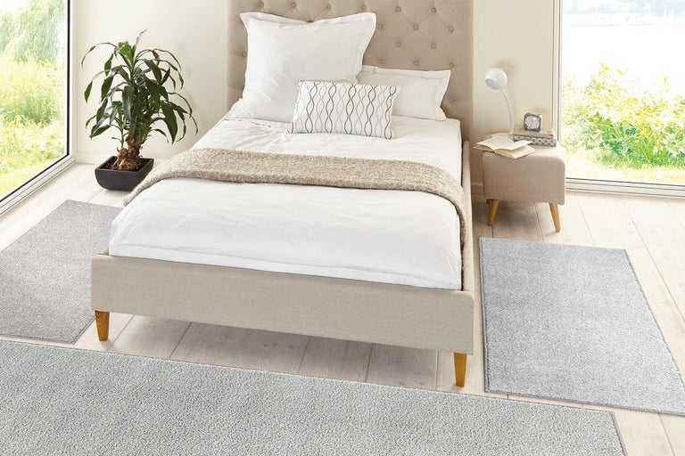 Lichte slaapkamer met bed, nachtkastje en vloerkleed