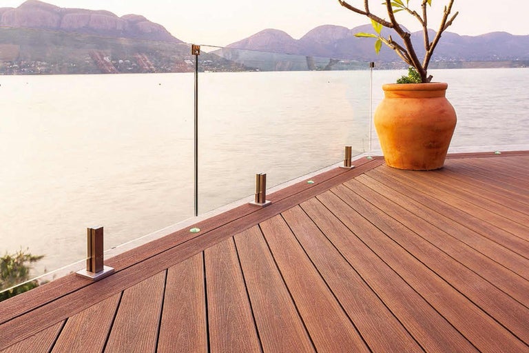 Terras met glazen balustrade en houten vloer met uitzicht op zee