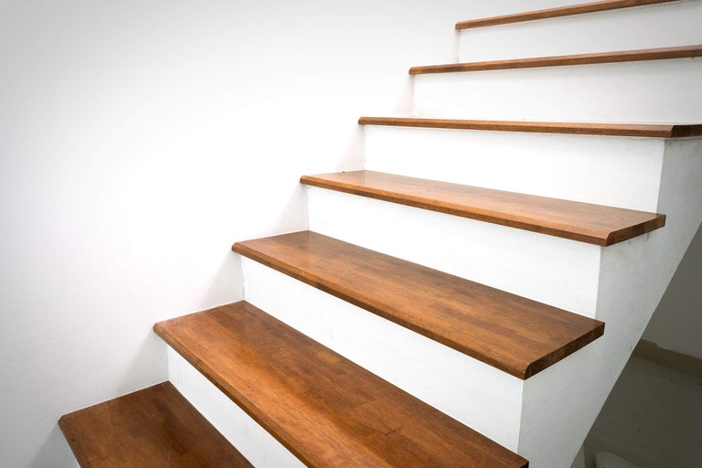 Trap met houten treden en wit trappenhuis