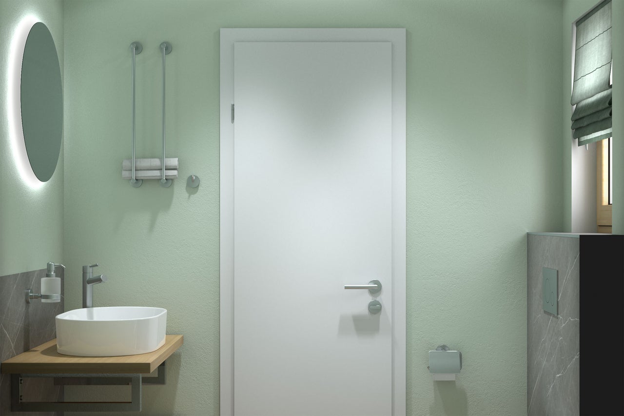 Moderne badkamer met lichtgroene wanden, witte binnendeur, ronde opzetwastafel op houten blad, verlichte spiegel en accessoires.