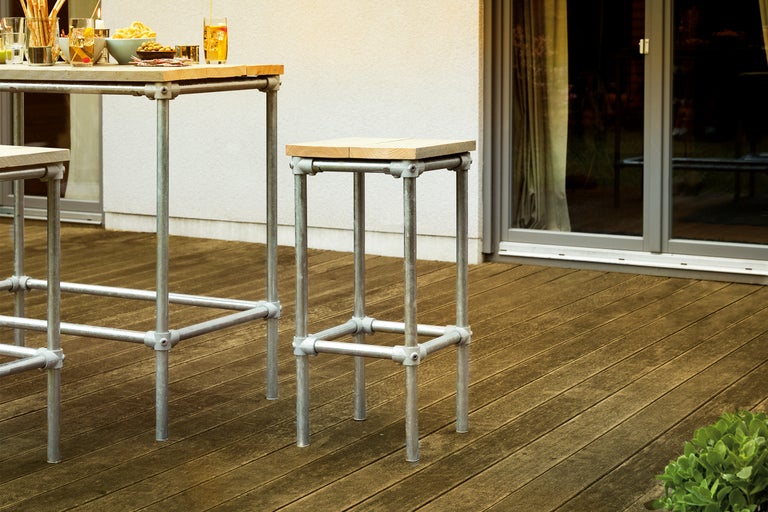 Barkruk en bartafel met stalen frame en houten blad op een terras