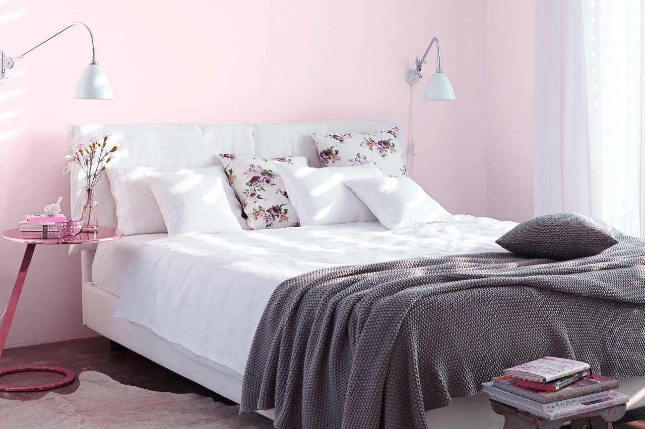 Uitnodigende slaapkamer met bed, kussens, deken en nachtkastje