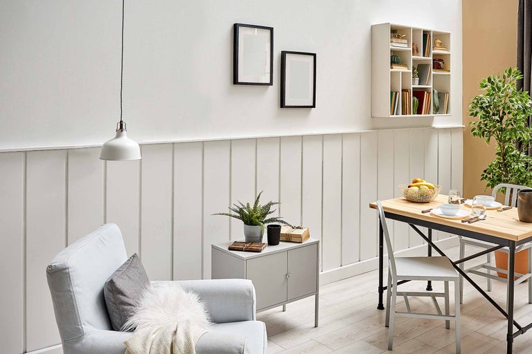 Lichte woonkamer met fauteuil, tafel, decoratie en wandrek