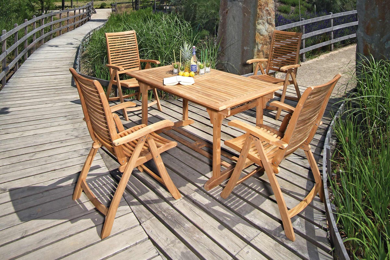 Tuinscene met teakhouten tafel en vier stoelen op houten terras