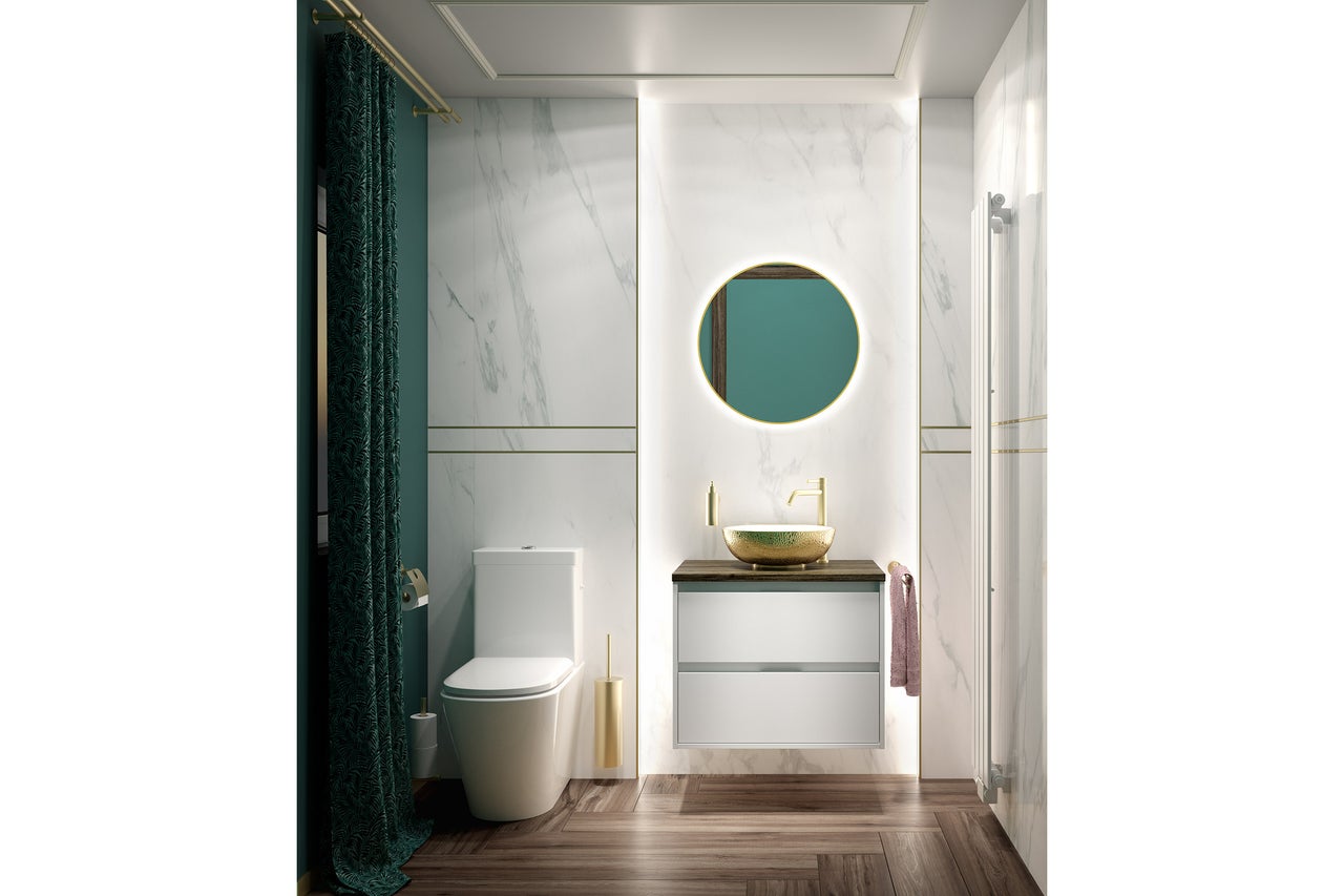 Moderne badkamer met wanden in marmerlook, gouden opzetwastafel, wit toilet, groen gordijn en donkere houten vloer.