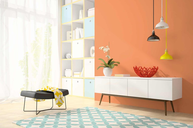 Woonkamer met rekken, dressoir, vloerkleed, kruk en hanglampen