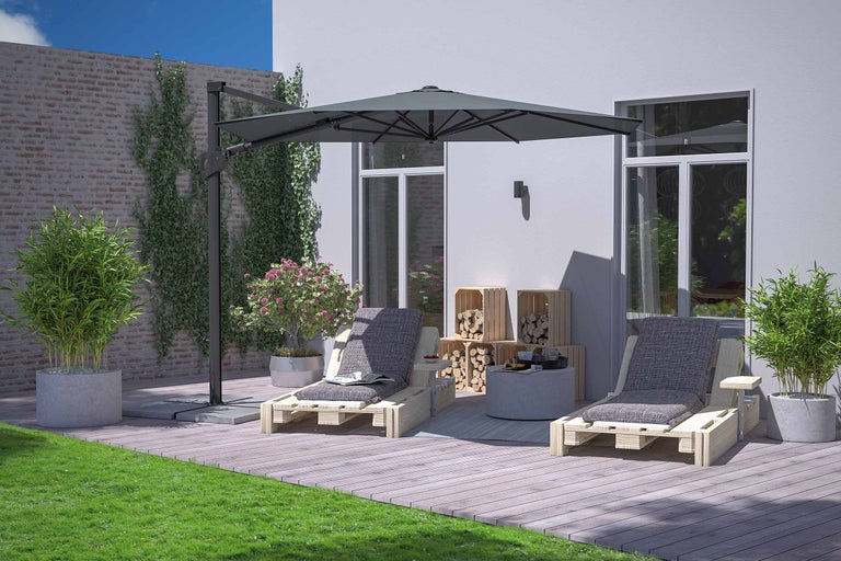 Tuin met twee houten ligstoelen onder een parasol die schaduw biedt.