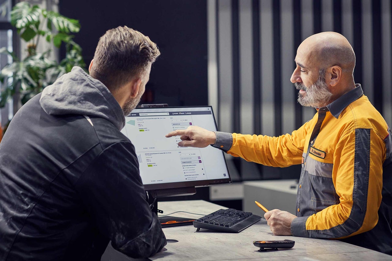 Een Hornbach medewerker adviseert een klant over producten op de computer.