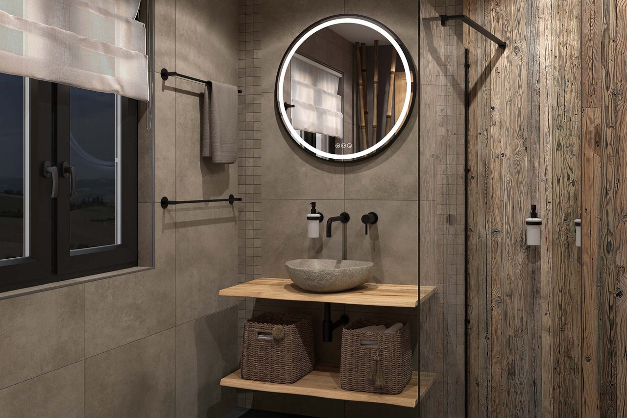Moderne badkamer met ronde LED-spiegel, stenen waskom op houten planken, wandkranen en tegels met steenlook.