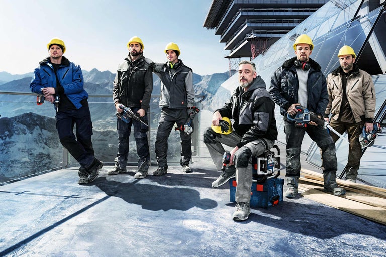Groep bouwvakkers met gereedschap en veiligheidskleding voor een bouwproject