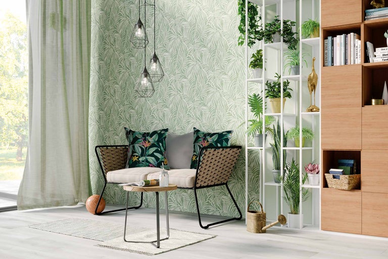 Woonkamer met zitbank, tafel, staande plank, kamerplanten en behang met bladerpatroon