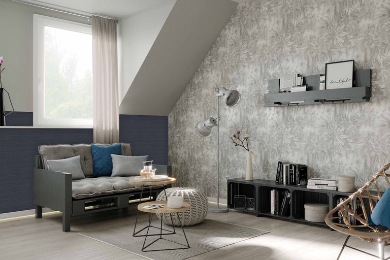 Woonkamer met bank, bijzettafels, staande lamp en patroonbehang voor een gezellige sfeer