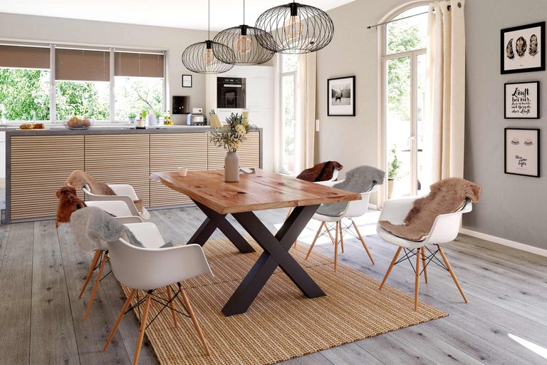 Eetkamer met houten tafel, stoelen, tapijt en verlichting in een lichte ruimte