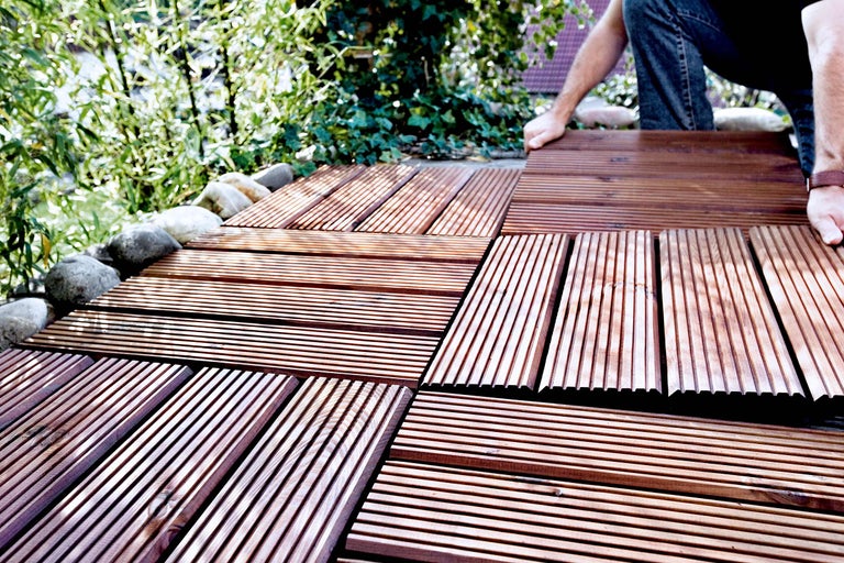 Installatie van bruine terrastegels in de tuin