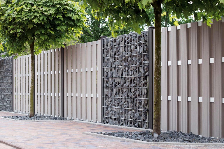 Tuinafscheiding van kunststof en schanskorven gevuld met stenen