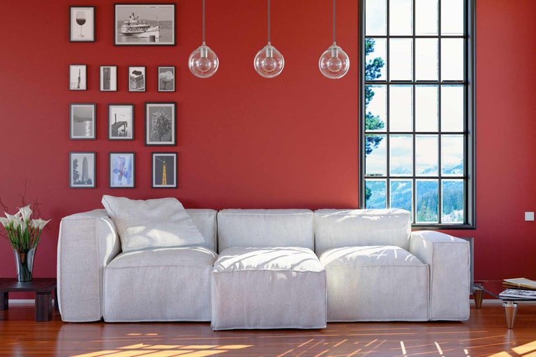 Woonkamer met witte bank, raam en wanddecoraties