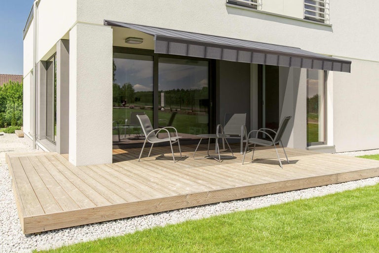 Terras met luifel, tuinmeubelen en houten vloer voor een woonhuis