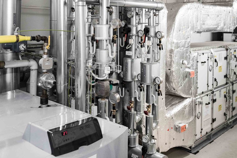 Complex verwarmings- en ventilatiesysteem met leidingen, meetinstrumenten en besturingseenheden.