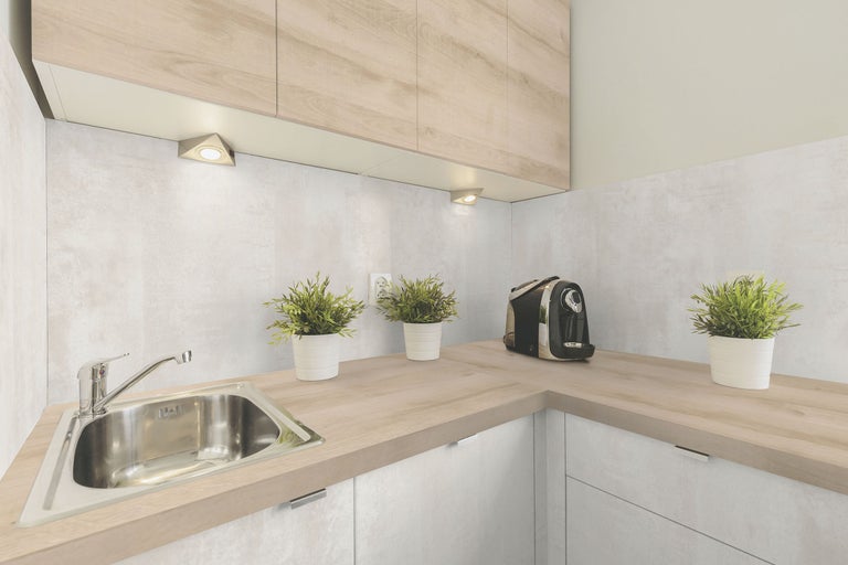 Lichte keuken met gootsteen, werkblad, bovenkasten en onderbouwverlichting