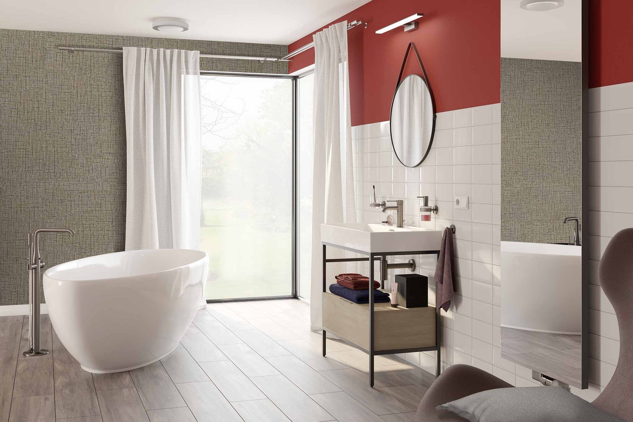 Moderne badkamer met vrijstaand bad, wastafel en daglicht