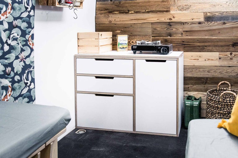 Interieur met ladekast, campingkooktoestel en houten kisten