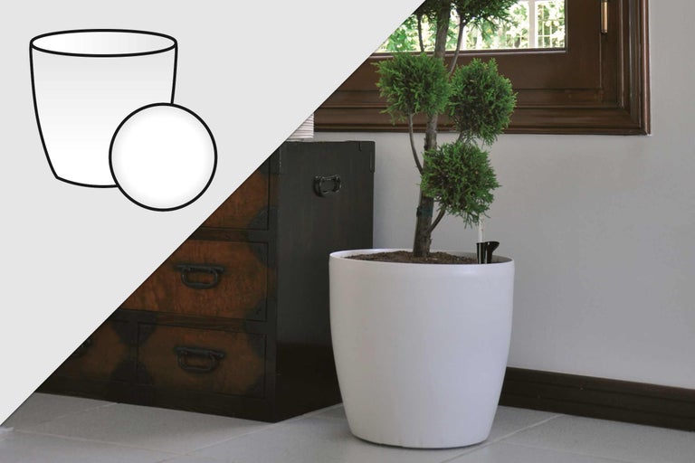 Witte bloempot met irrigatiesysteem en plant