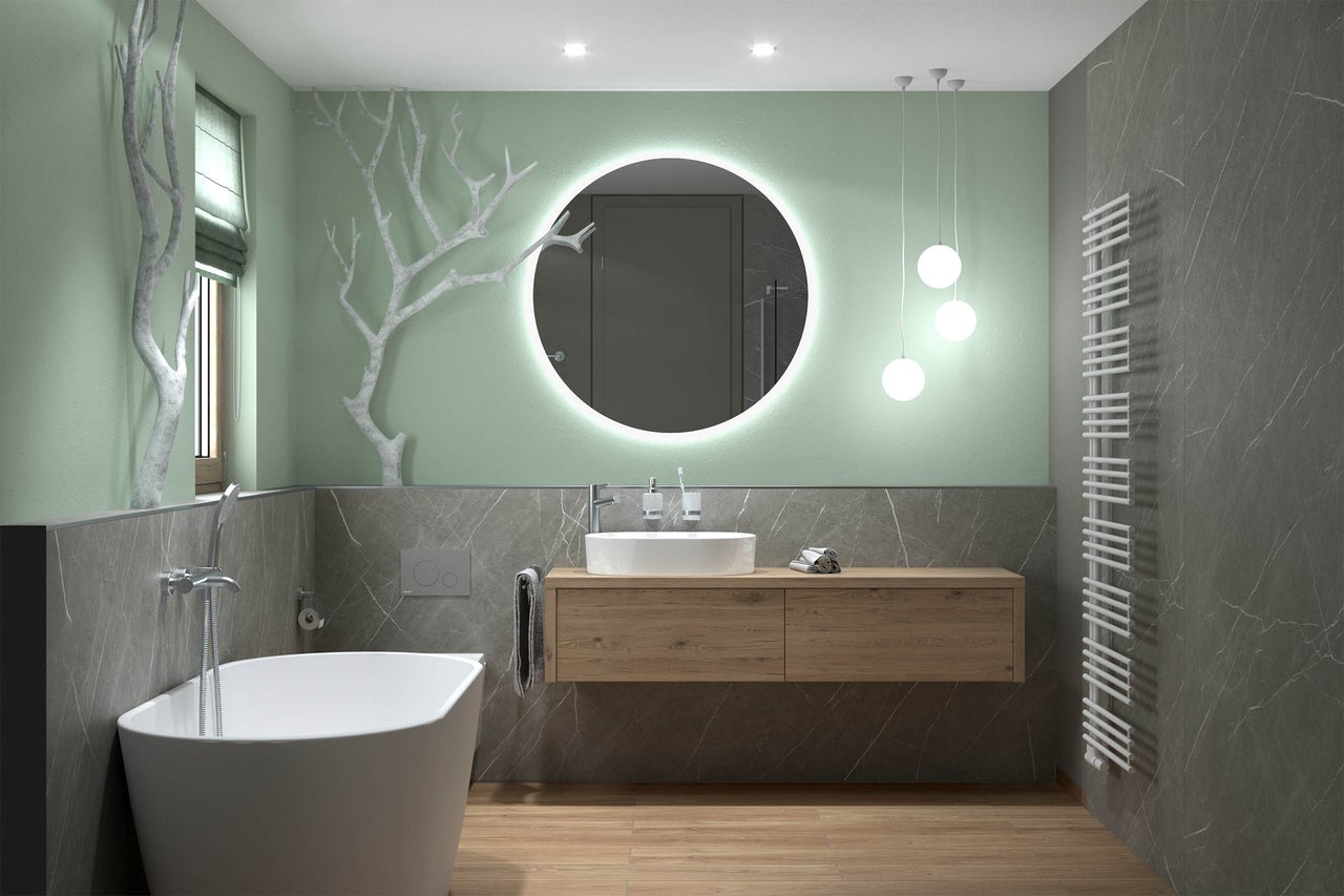 Moderne badkamer met vrijstaand bad, houten wastafelmeubel, ronde LED-spiegel en grote tegels met marmerlook.