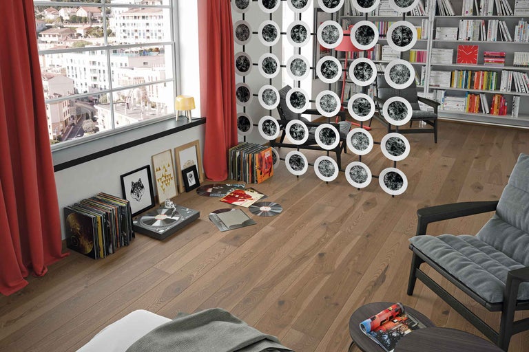 Woonkamer met platencollectie, platenspeler, scheidingswand en houten vloer