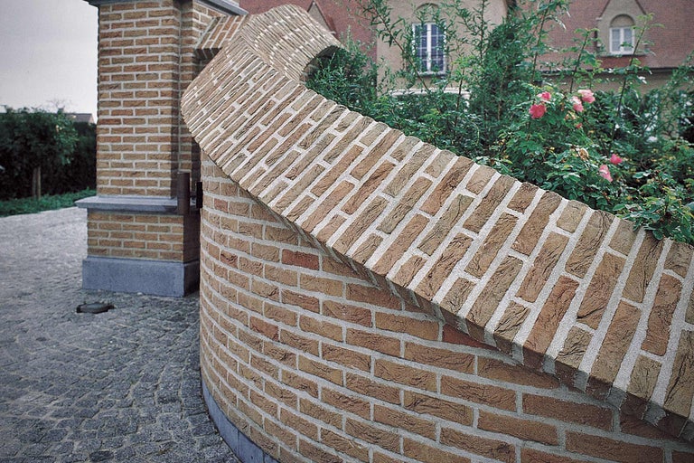 Gebogen muur van bakstenen in een tuin