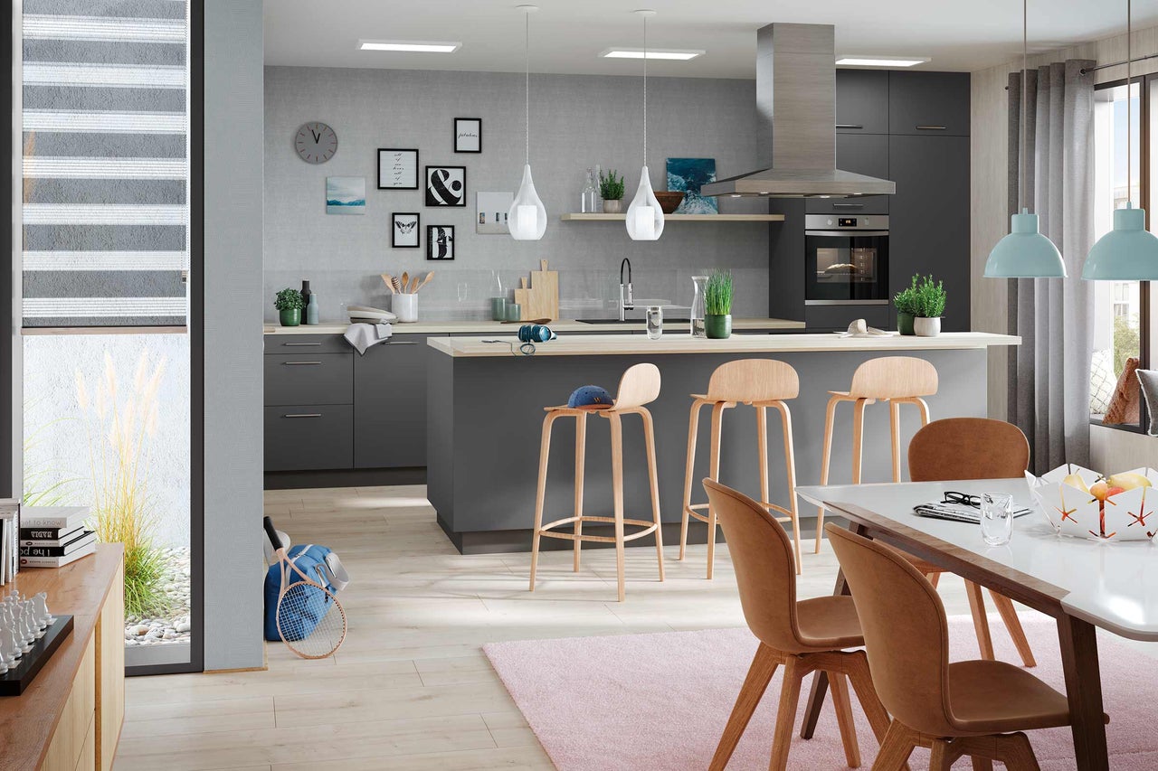 Moderne keuken met kookeiland, barkrukken en eethoek voor een heldere, uitnodigende sfeer.